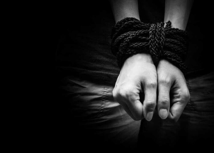 Human trafficking. Hands bound together,
